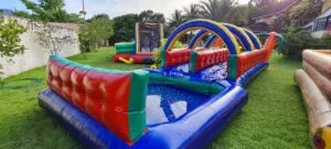 Foto de um grande brinquedo inflável modelo Slide Radical, com uma rampa de escorregar bem íngreme e paredes de escalada, pronto para quem quer alugar um brinquedo inflável emocionante.