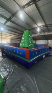 Crianças se divertindo no brinquedo de escalada inflável colorido, disponível para aluguel em festas e eventos